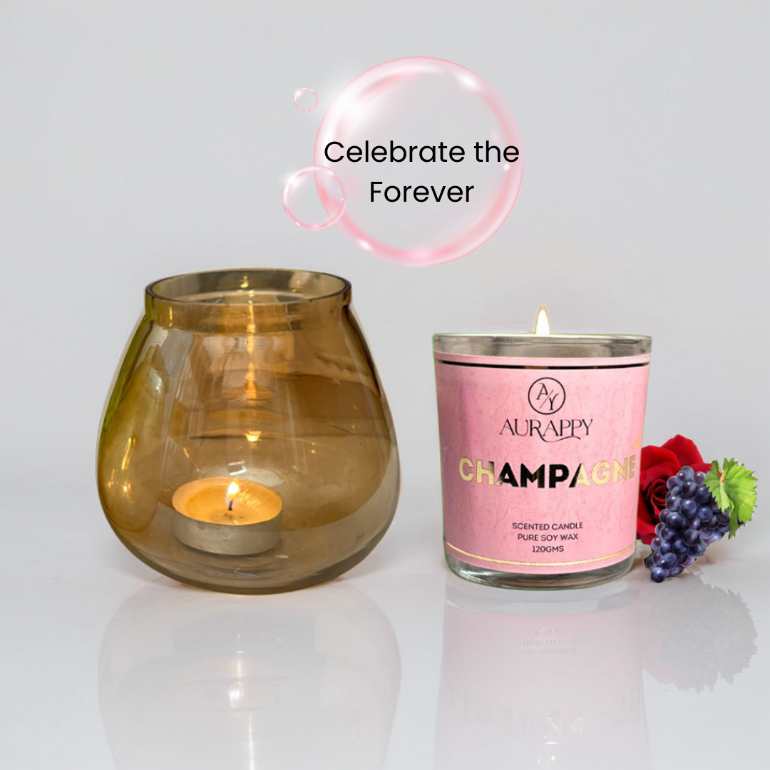 Two candles, one in a glass holder and the other in a pink container labeled 'Champagne', with decorative elements on a light background.