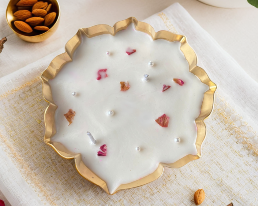 Decorative urli candle with pearls and flowers on a white surface with almonds and flowers.