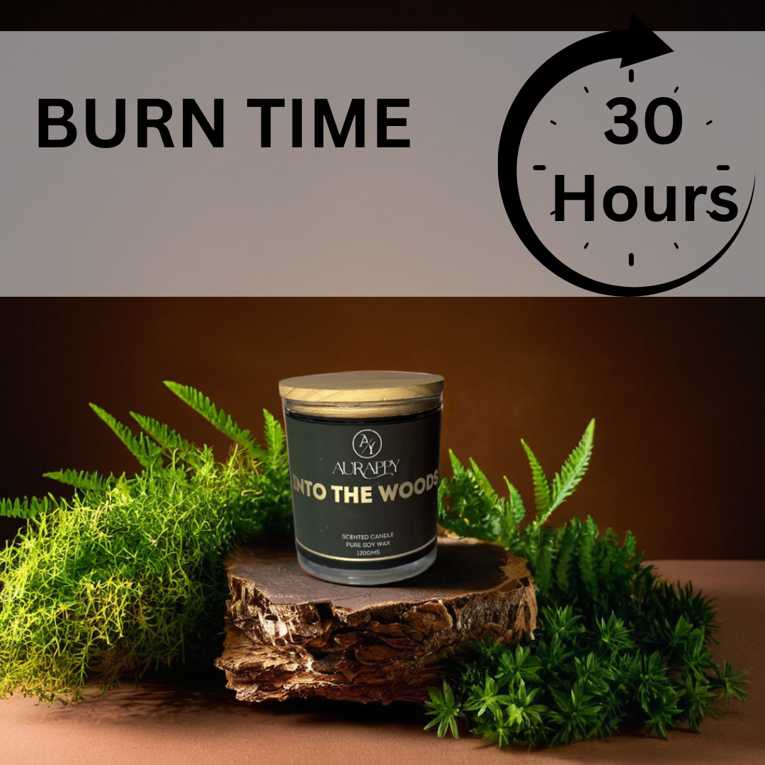Candle with 'Into The Woods' scent on a wooden stump surrounded by greenery, with text indicating burn time.