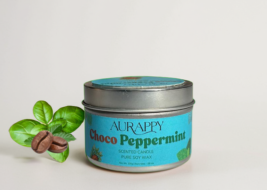 Aurappy Choco Peppermint scented candle in a tin with a decorative leaf and candy on a light background
