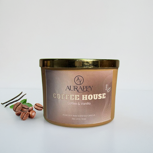 Aurappy Coffee House candle with coffee beans and vanilla leaves on a white background